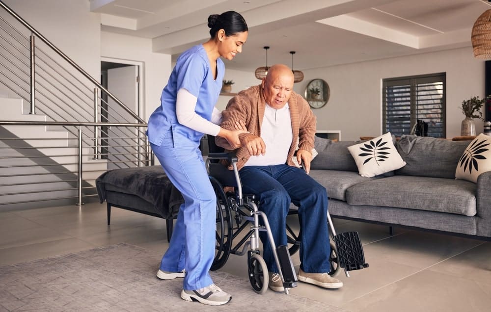 Pflegefachkraft finden - Pflegerin hilft älterem Herren aus dem Rollstuhl